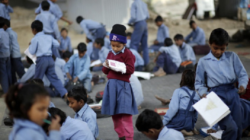 Schoolgirl Reads From A Textbook At An Open Air School In New Delhi